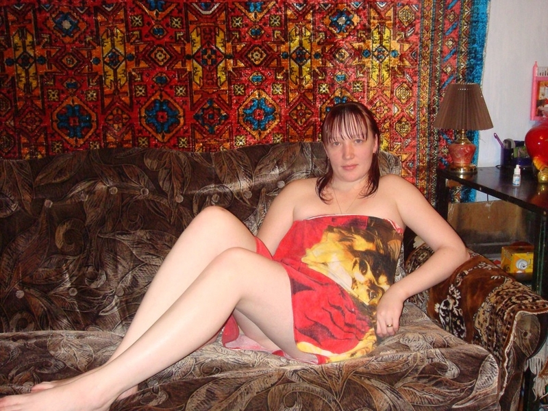 Обнаженная леди позирует на кровати на фоне ковра